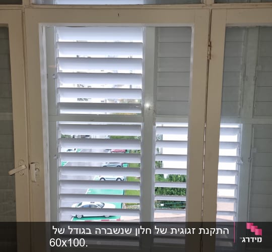 חלון זכוכית עם תריסים פתוחים חלקית